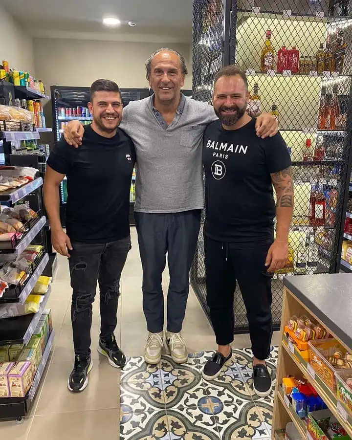 Τρεις άνθρωποι του καταστήματος ανάμεσα στα ράφια του παντοπωλείου